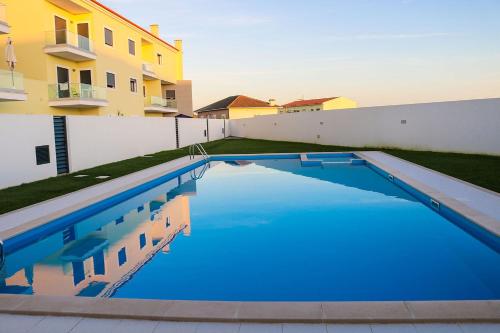 a swimming pool in front of a building at Ocean Pearl Baleal in Ferrel