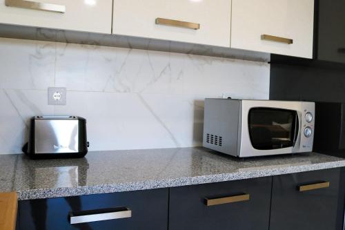 a microwave sitting on top of a kitchen counter at Ocean Pearl Baleal in Ferrel