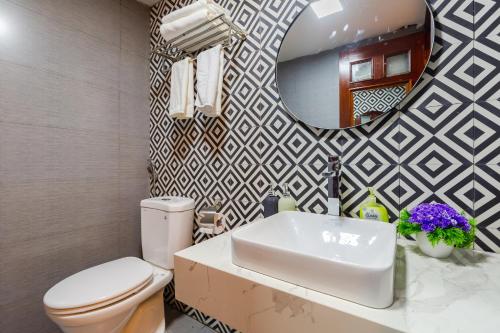 ハノイにあるOhana Hotelのバスルーム(トイレ、洗面台、鏡付)