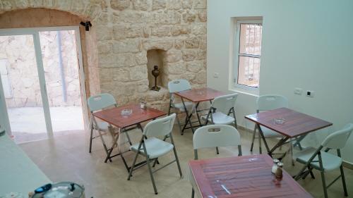 a room with tables and chairs and a stone wall at Angel's house in Nazareth