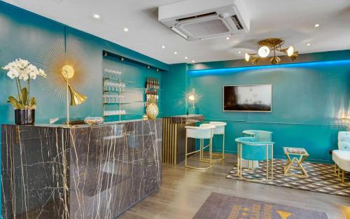 a blue room with a bar with stools at Carladez Cambronne in Paris