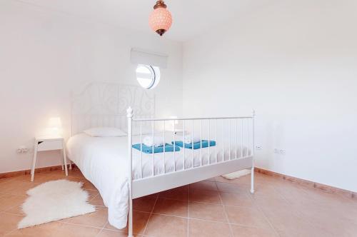 una camera bianca con letto bianco e specchio di Apartment Praia da Arrifana! ad Aljezur