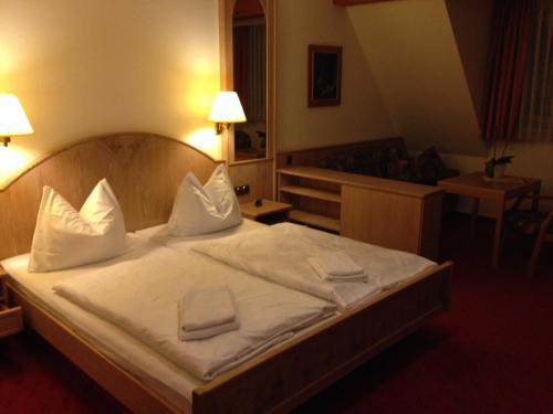 een slaapkamer met een bed met witte lakens en kussens bij Hotel "Zur Panke" in Kolonie Röntgental