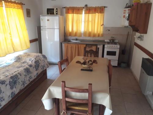 a small kitchen with a table and a bed at Complejo Sagrado Corazón in Merlo