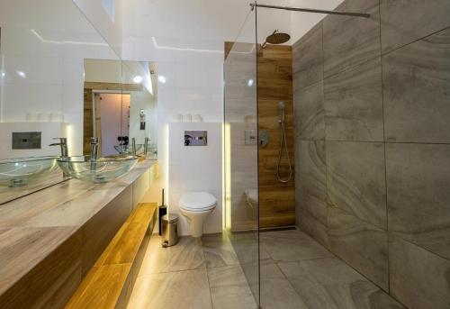 łazienka z 2 umywalkami, toaletą i prysznicem w obiekcie APARTAMENTY NAD CAFE w mieście Ustrzyki Dolne