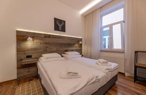 1 dormitorio con 1 cama grande y pared de madera en APARTAMENTY NAD CAFE en Ustrzyki Dolne