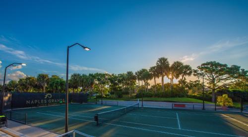 a tennis court with a tennis racket on a sunny day at Naples Grande Beach Resort in Naples