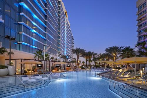 a swimming pool with chairs and umbrellas in a hotel at Seminole Hard Rock Hotel and Casino Tampa in Tampa
