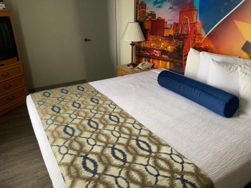 a hotel room with a large bed with a blue pillow on it at Ramada by Wyndham Nashville/Music Valley in Nashville