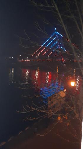 a bridge over the water at night at apartament z widokiem na jezioro in Mikołajki