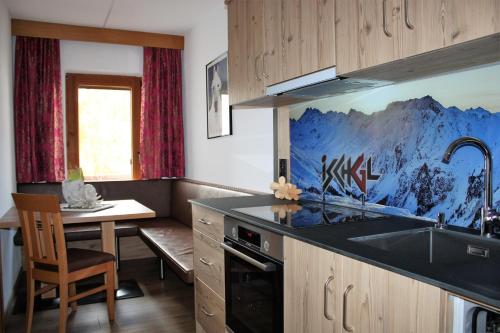 una cucina con lavandino e tavolo con sala da pranzo di Hubertus Appartements a Ischgl