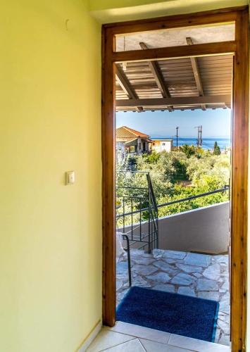 a door to a balcony with a view of the ocean at Alexandra Apartments in Stoupa
