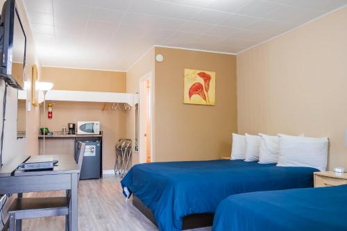 una camera d'albergo con un letto blu e una scrivania di Lakeview Motel a Christina