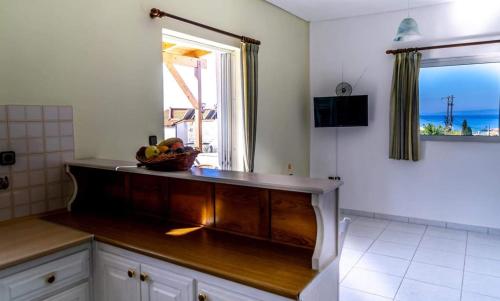a kitchen with a bowl of fruit on a counter at Alexandra Apartments in Stoupa