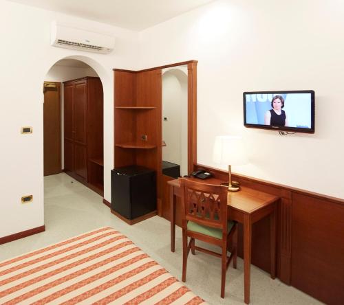 
a living room with a tv and a desk at Hotel Villa Adriana in Monterosso al Mare
