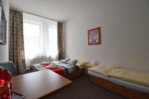 a hotel room with two beds and a table at Penzion B5 in Kežmarok