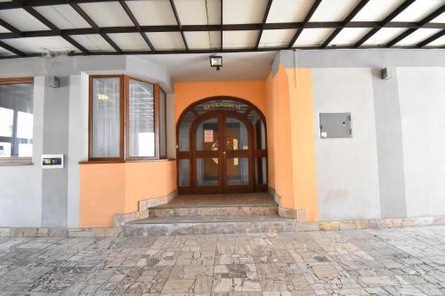 an orange and white building with a wooden door at Penzion B5 in Kežmarok