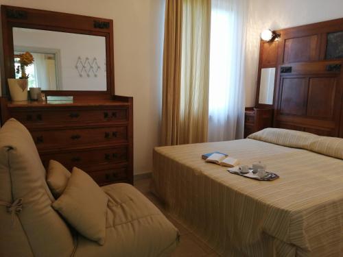 a bedroom with a bed and a dresser and a mirror at Vacanze Toscane In The Country in Sassetta
