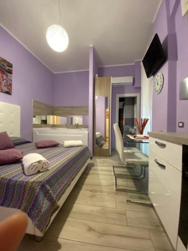 a purple bedroom with a bed and a desk at al Corso 203 in Salerno