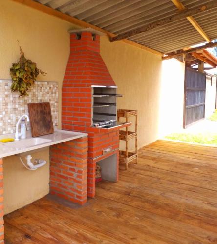 an outdoor kitchen with a brick oven in a room at Pousada Ilha Sul in Cananéia
