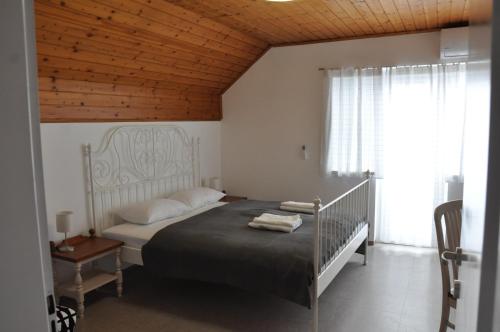 1 dormitorio con 1 cama con techo de madera en Vas Lipa 8 - 36, en Podčetrtek