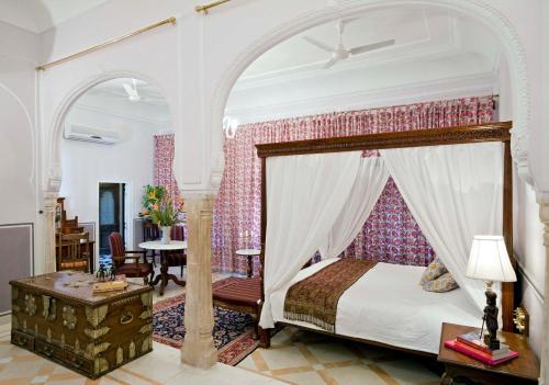 a bedroom with a canopy bed and a table at Samode Palace in Sāmod