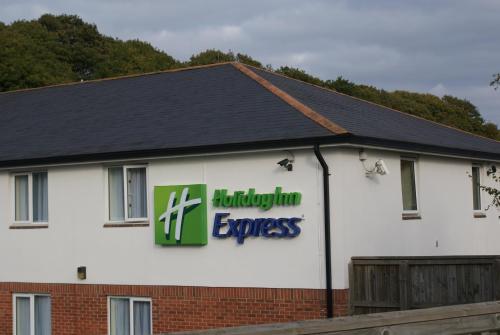 a building with a sign on the side of it at Holiday Inn Express Canterbury by IHG in Canterbury
