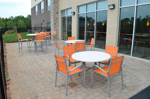 a group of tables and chairs sitting outside of a building at Holiday Inn Express & Suites - Charlotte NE - University Area by IHG in Charlotte