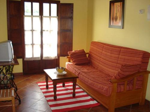 a living room with a couch and a coffee table at Apartamentos Rurales El Molín de Panizal in San Cosme