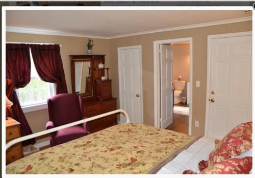 a bedroom with a bed and a chair and a window at Cornwall Inn in Cornwall Bridge