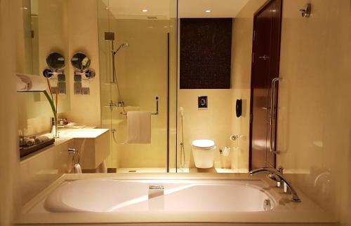 a bathroom with a large tub and a shower at Crowne Plaza Kochi by IHG in Cochin