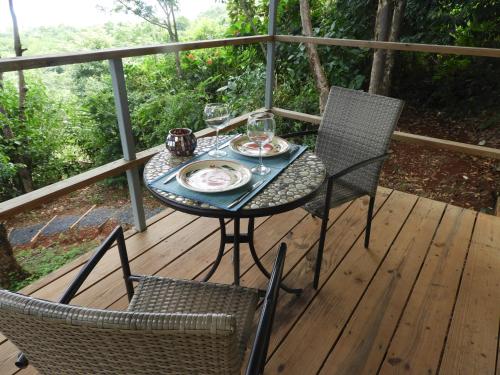 a table and two chairs on a wooden deck at El nido del tucán in Torio