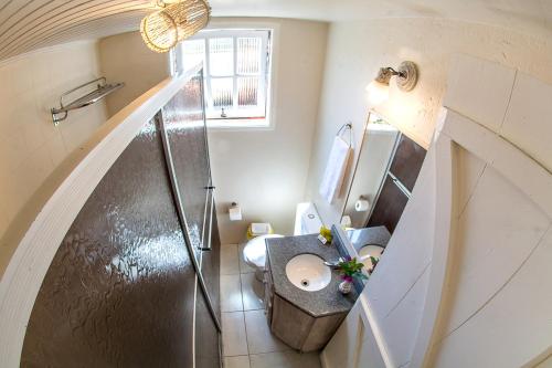 a bathroom with a sink and a toilet and a staircase at Pousada Rosa in Praia do Rosa