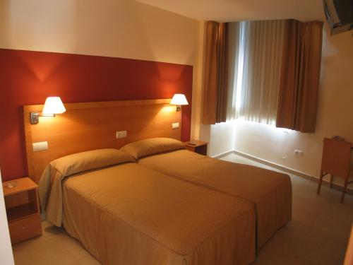 Habitación de hotel con cama grande y 2 almohadas en Hostal Ciudad de Cáparra, en Carcaboso