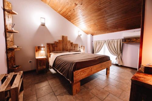 - une chambre avec un grand lit et un plafond en bois dans l'établissement Agriturismo la Bicocca, à Sermide