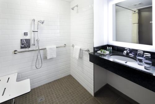 Baño blanco con lavabo y espejo en The Lodge at Duke Medical Center en Durham