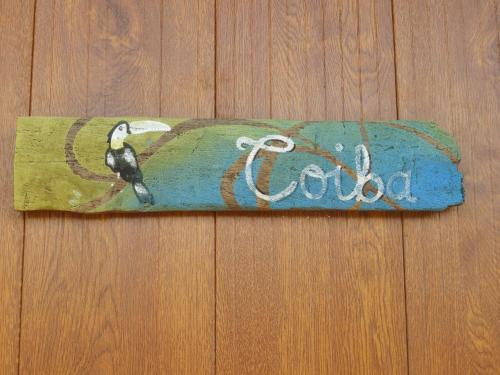 a sign with a bird on it on a wooden floor at El nido del tucán in Torio