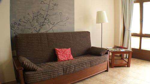 un sofá con una almohada roja en la sala de estar en Anticforn, en Bohí