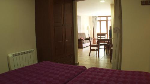 a bedroom with a purple bed and a dining room at Anticforn in Bohí
