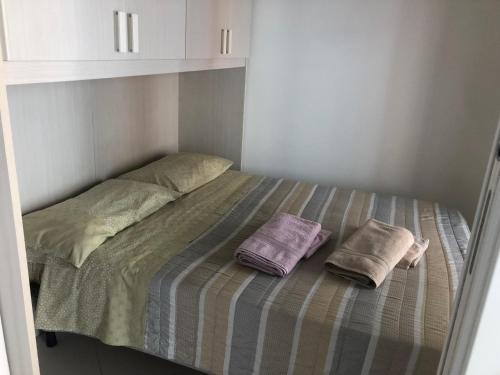 un lit avec deux oreillers dessus dans une chambre dans l'établissement West bay, à Menton