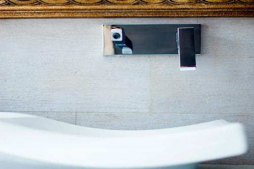 a mirror on a wall with a camera at La Posada de las Casitas in Ampudia