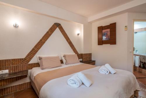 タヴィラにあるPedras del Rei, Nature and Beach Apartmentのベッドルーム1室(ベッド2台、タオル付)