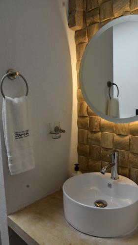 y baño con lavabo blanco y espejo. en Hotel Zamna Boutique en Mérida