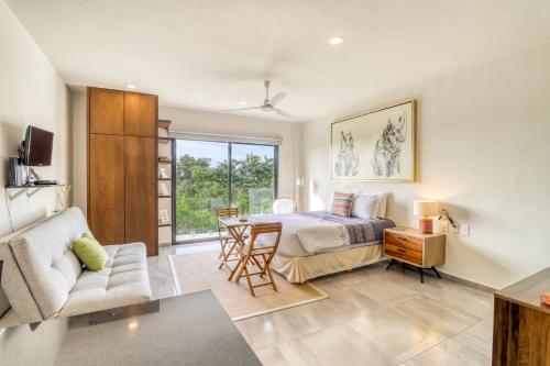 1 dormitorio con 1 cama y sala de estar en Zulim Condo - 302 en Playa del Carmen
