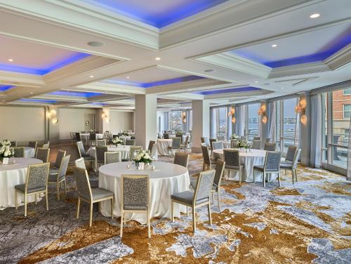 a banquet room with tables and chairs and windows at Battery Wharf Hotel, Boston Waterfront in Boston