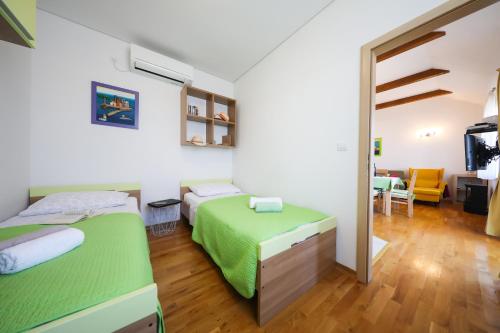 a bedroom with two beds and a living room at Apartment Milka with sea view in Tisno