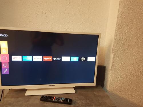 a television with a remote control next to a wall at Apartamento CabezoDoce in Calahorra
