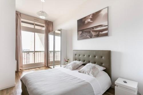 a bedroom with a large bed and a large window at Loft Triangle comedie, Parking free in Montpellier
