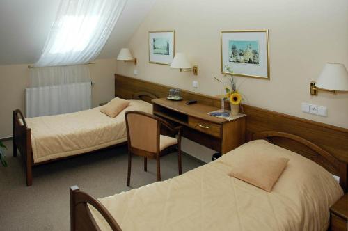 Habitación de hotel con 2 camas y escritorio en Hotel Restaurant Modrá Hvězda en Dobřany