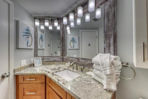 a bathroom with a sink and a large mirror at Bluewater Apartments in Orange Beach